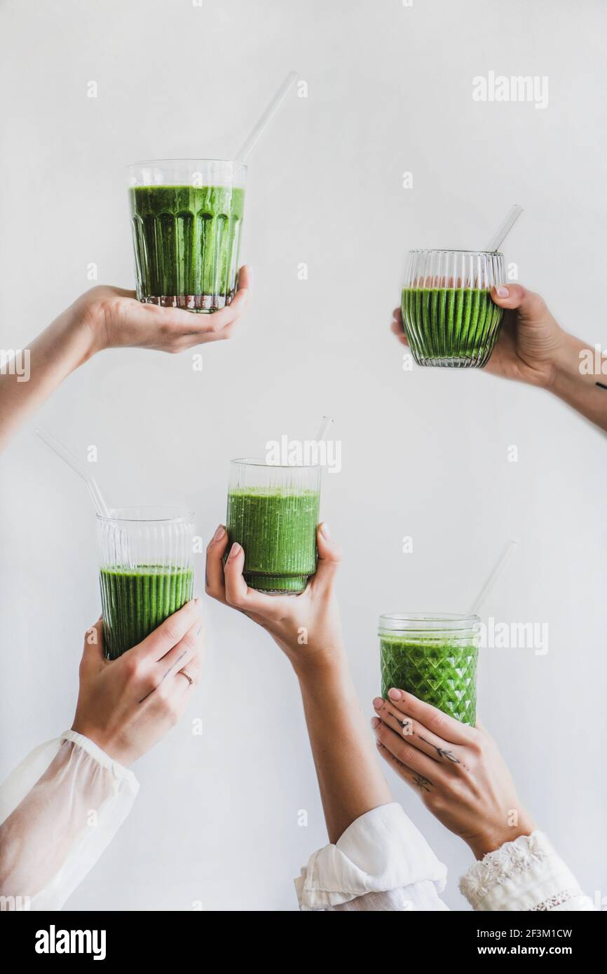 Glasses of detox healthy green smoothie in hands Stock Photo
