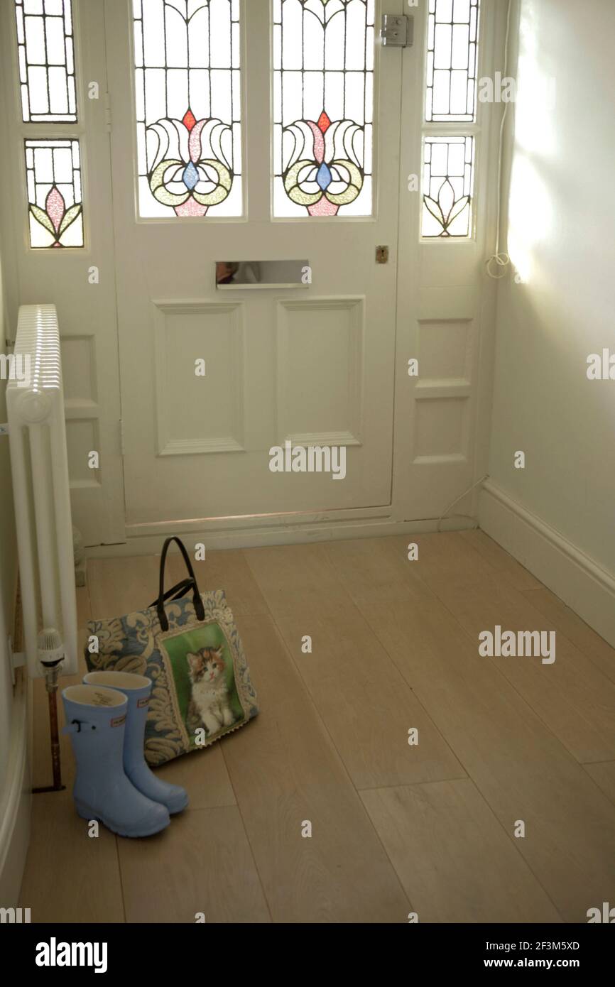 Hallway with stained glass door, wellies and bag Stock Photo Alamy