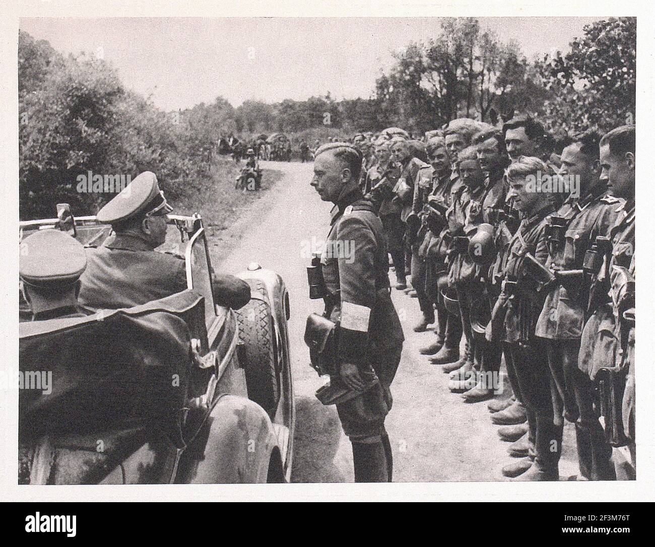 World War II period from German propaganda news. German Commander (Gerd von Rundstedt?) greets his soldiers during the victory march in France. 1940 Stock Photo