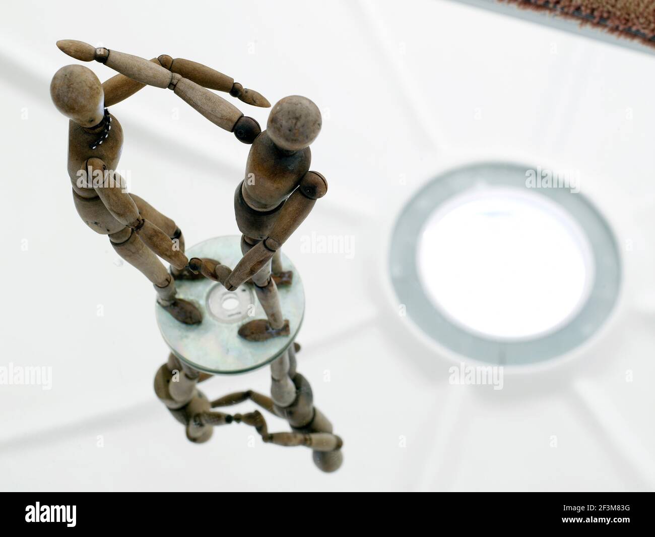 Close up of two wooden figures on table with mirrored surface in residential house, Brazil Stock Photo
