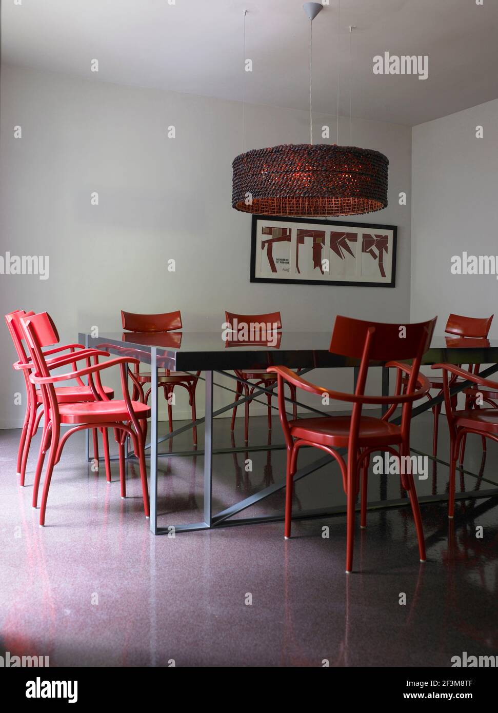 Dining table and chairs with hanging light in French residential home. Stock Photo