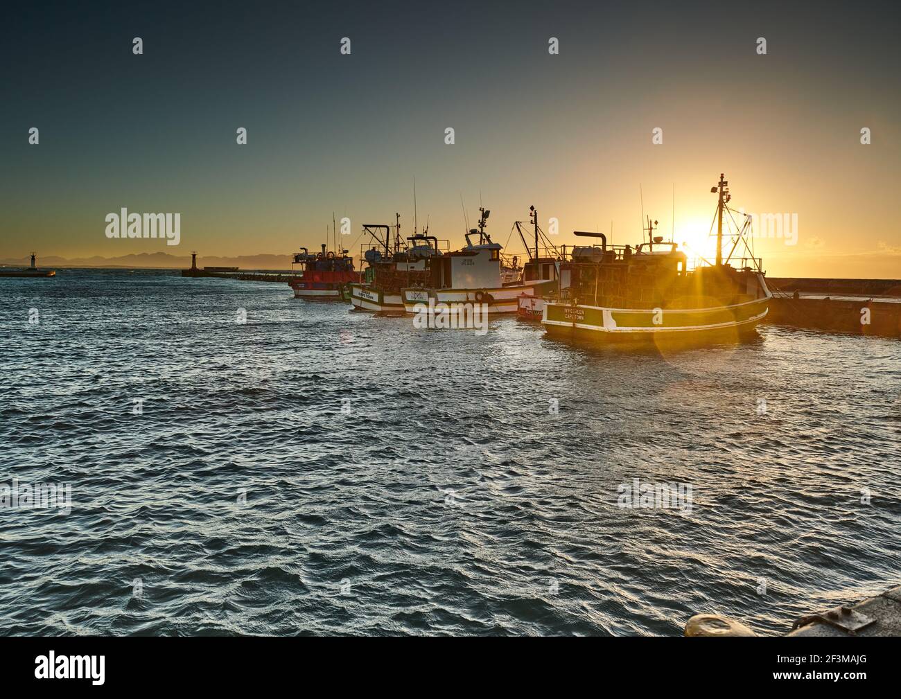Sunrise over fishing boats in Kalk Bay Harbour, Cape town Stock Photo