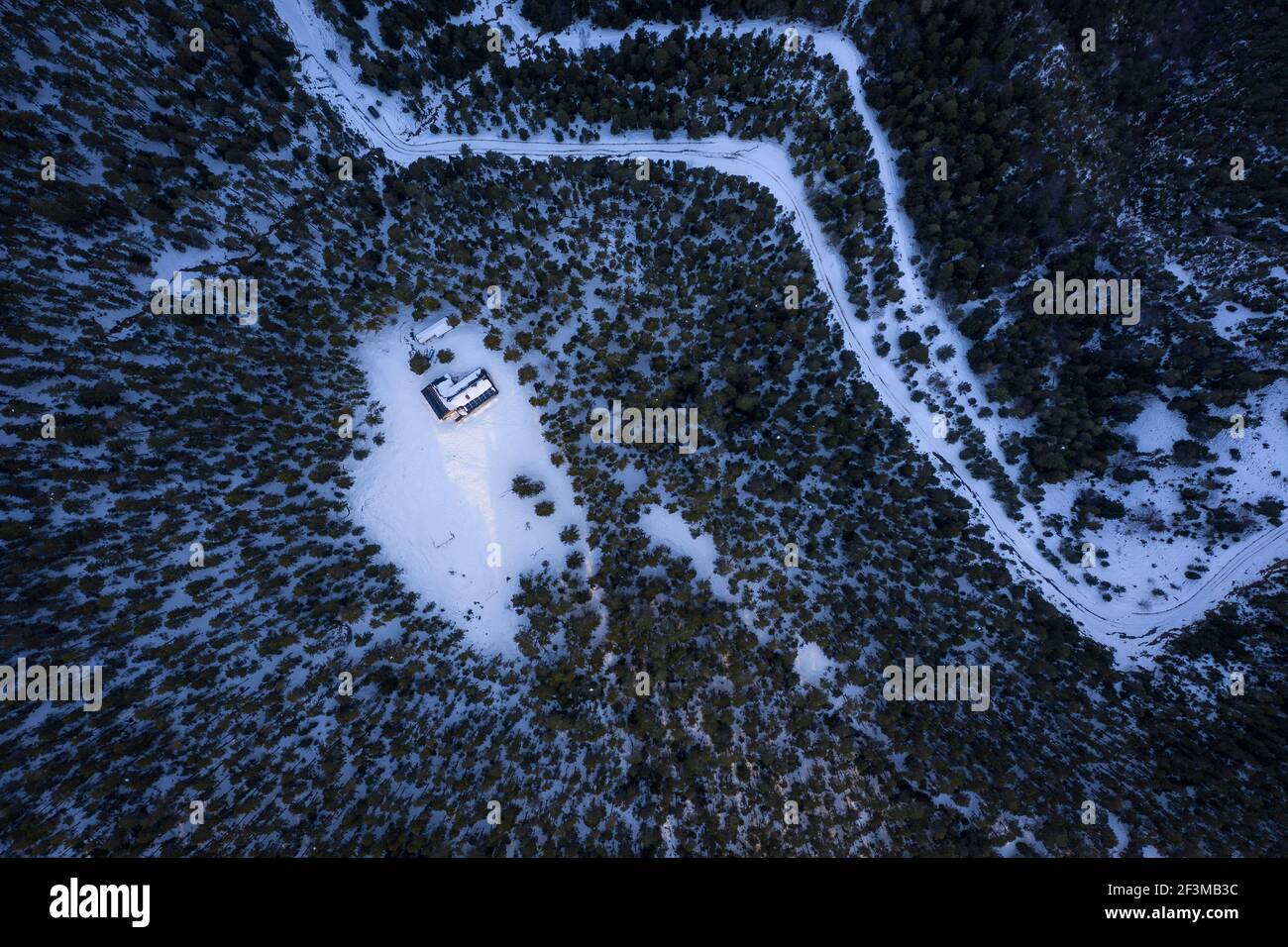 Overhead aerial view of Lluís Estasen mountain hut after a winter snowfall in a cloudy day (Barcelona province, Catalonia, Spain, Pyrenees) Stock Photo