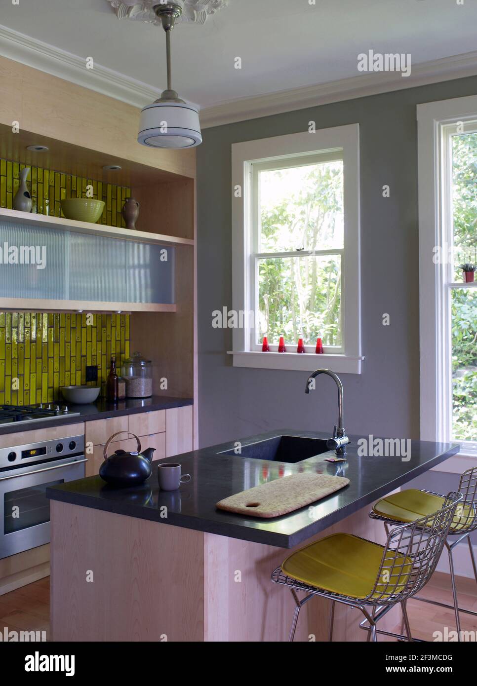 Breakfast bar and sink unit in kitchen with green mosaic tiling in ...