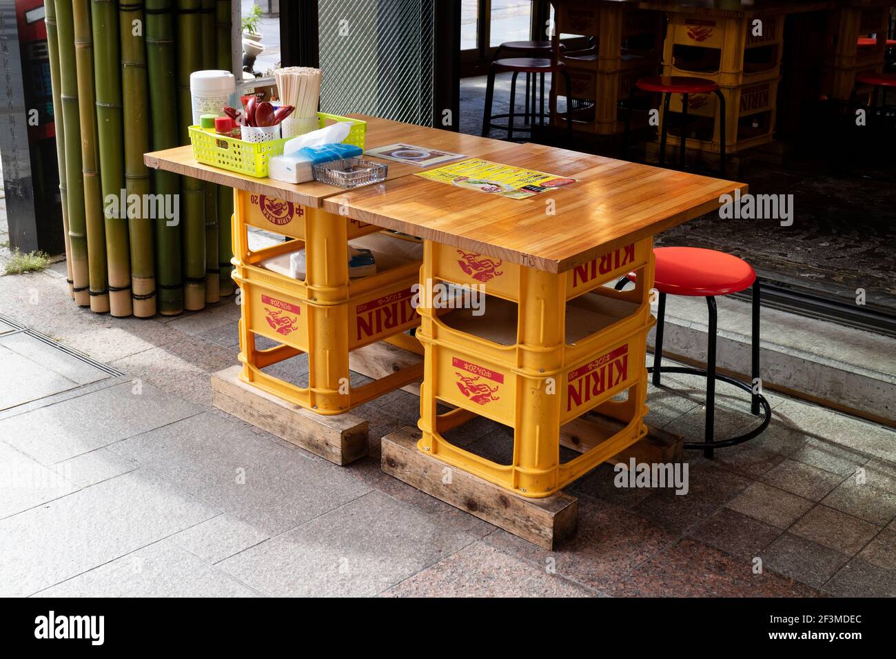 Second use of  empty beer crates as an office desk outdoors in front of the store Stock Photo
