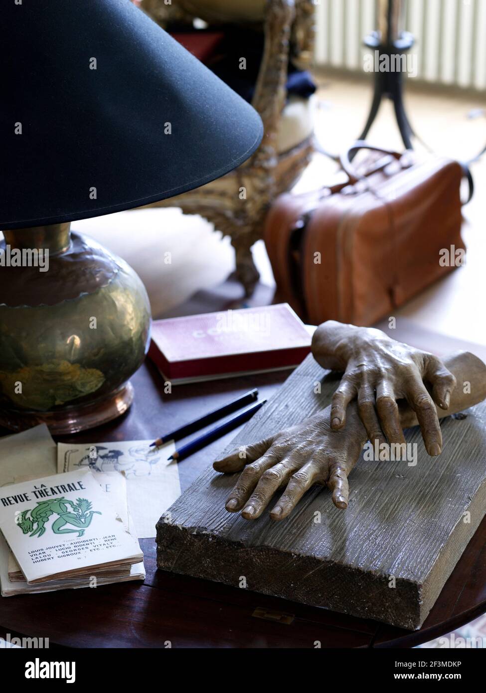 Moulded hands sculpture on desk with lamp in residential house, France. Stock Photo