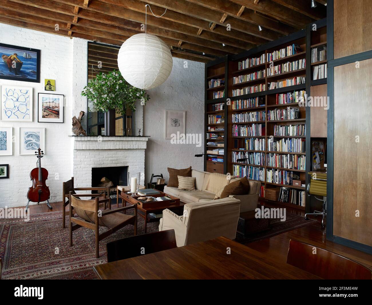 Rustic beamed ceiling living room with floor to ceiling wooden book ...