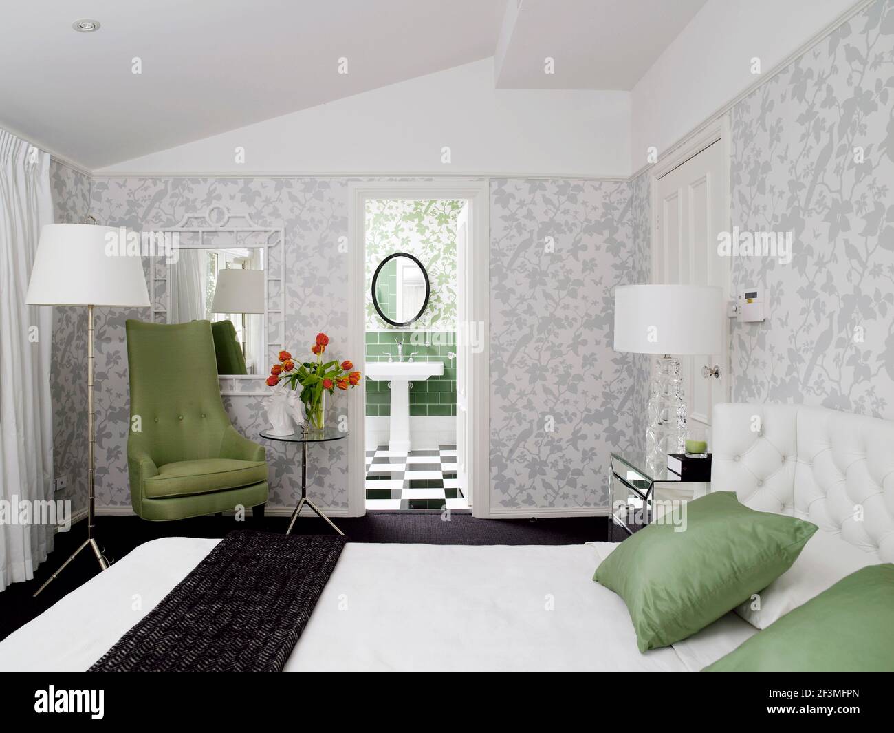 Bedroom with double bed, armchair and view through open door into en