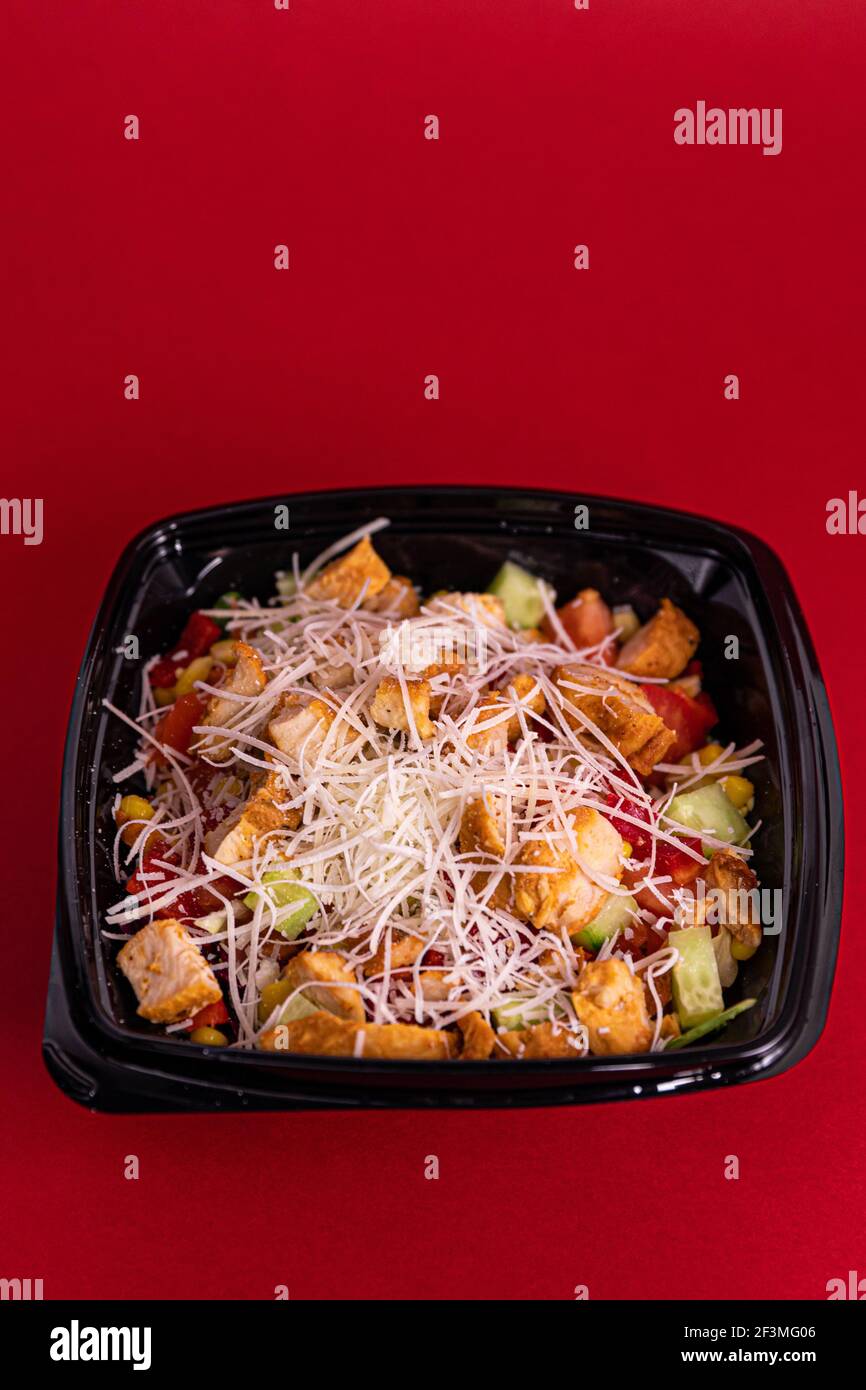 https://c8.alamy.com/comp/2F3MG06/a-fresh-delicious-salad-with-chicken-pieces-in-a-black-single-use-container-on-the-table-2F3MG06.jpg