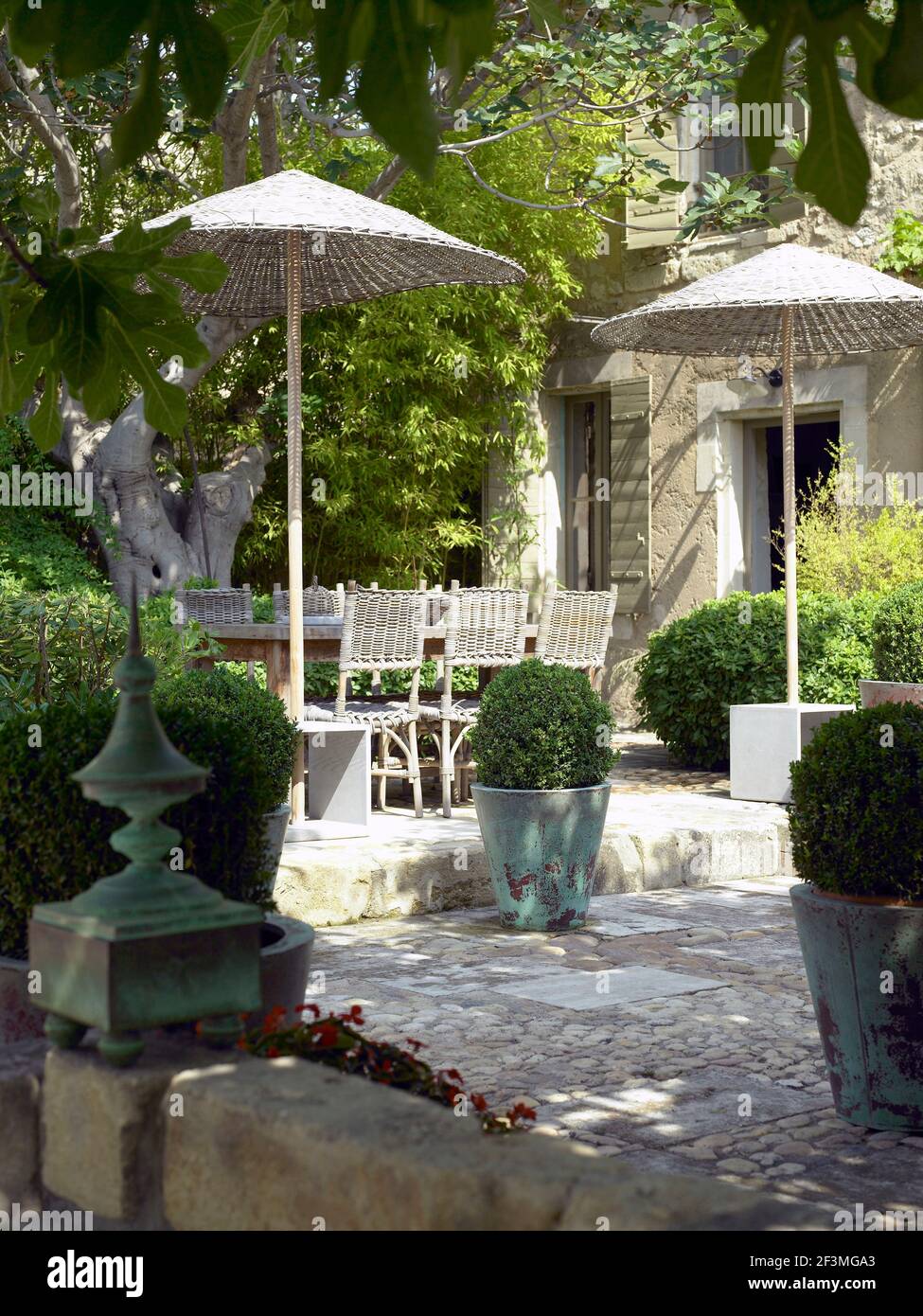 Wicker chairs and parasols on outdoor terrace, France Stock Photo