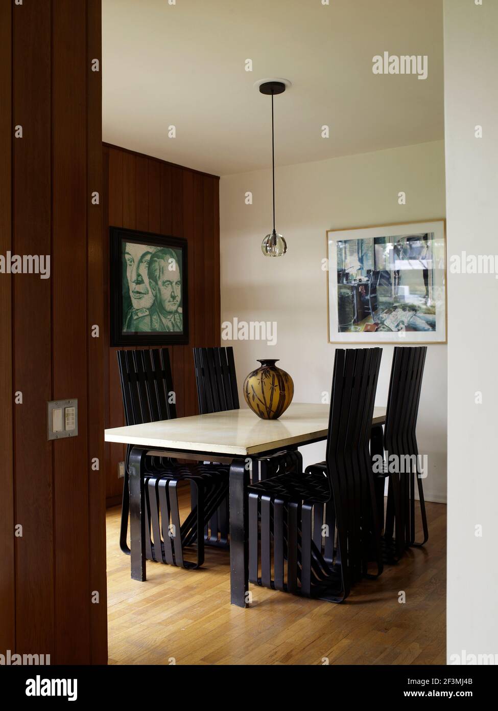 Dining table for four with black highbacked chairs in California home