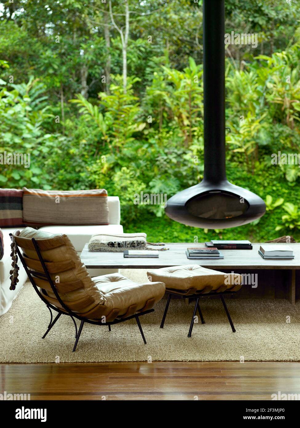 Chair and footstool in living room with suspended stove in Brazilian home, Brazil Stock Photo