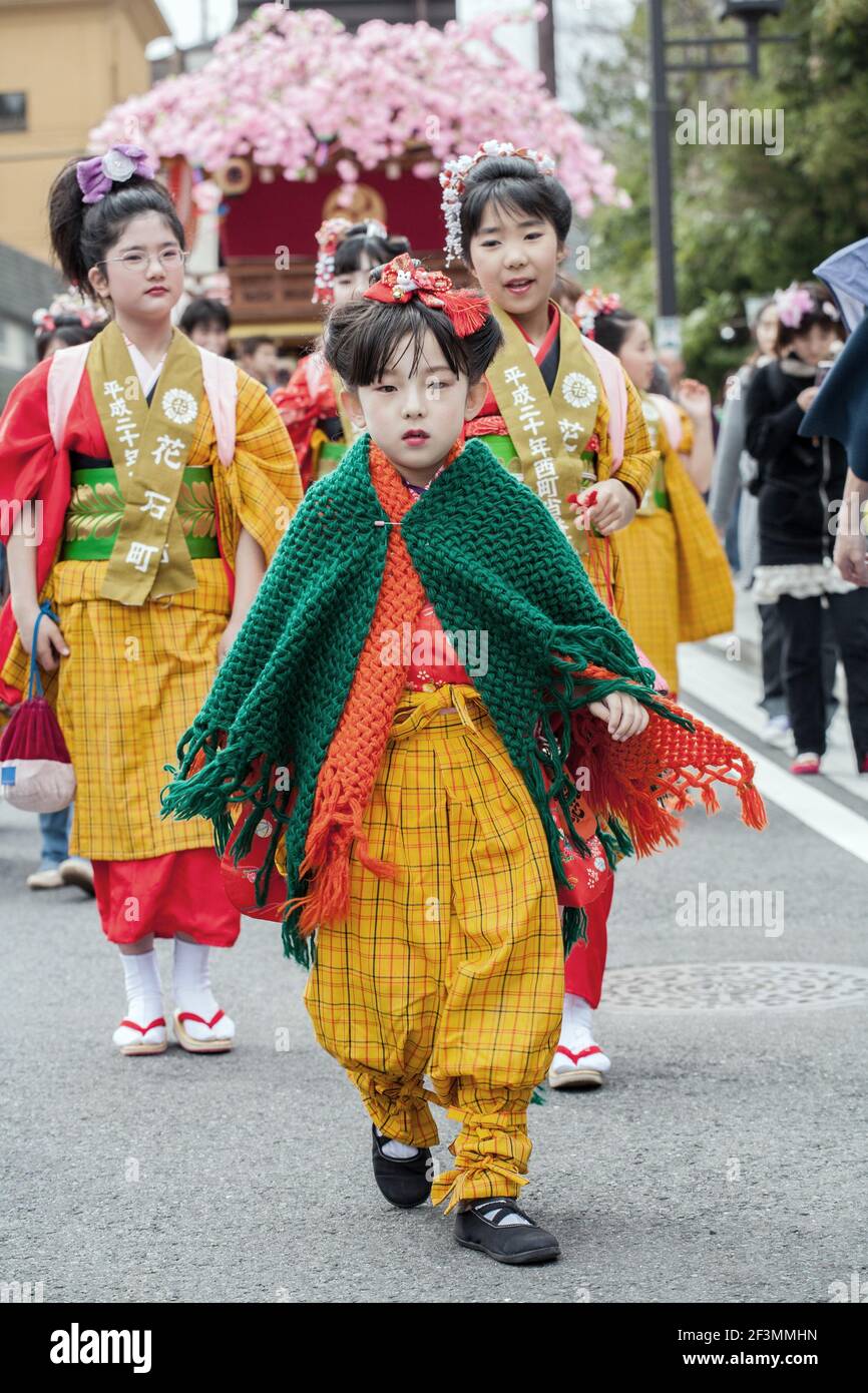 Young Japanese female leads the procession of floats (hanayatais) at the annual Yayoi Matsuri to celebrate the start of spring, Nikko, Japan Stock Photo