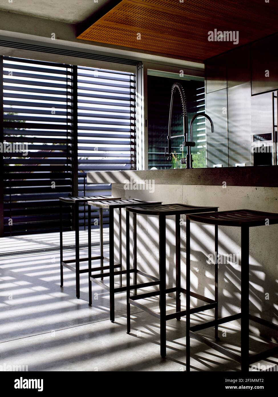 Bar stools at breakfast bar in kitchen in New Zealand home Stock Photo Alamy