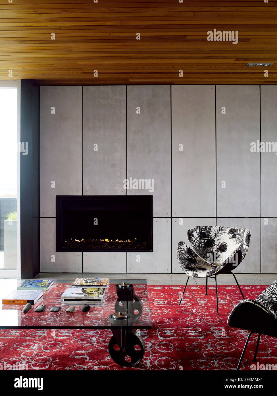 Glass topped coffee table in front of fireplace in living room in New Zealand home Stock Photo