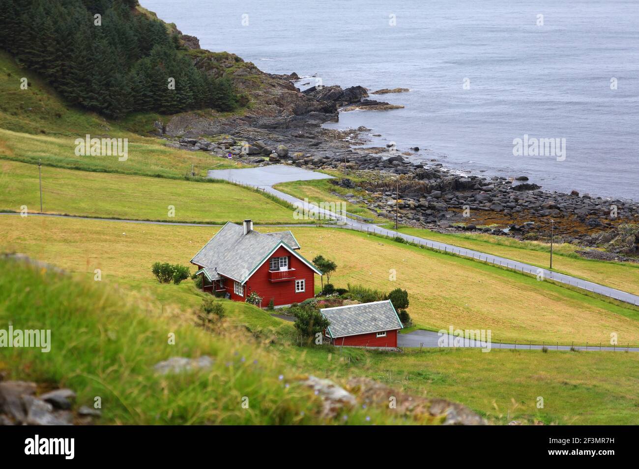 Runde island rural landscape in Norway. Traditional Norwegian village architecture style with falun red colored homes. Stock Photo