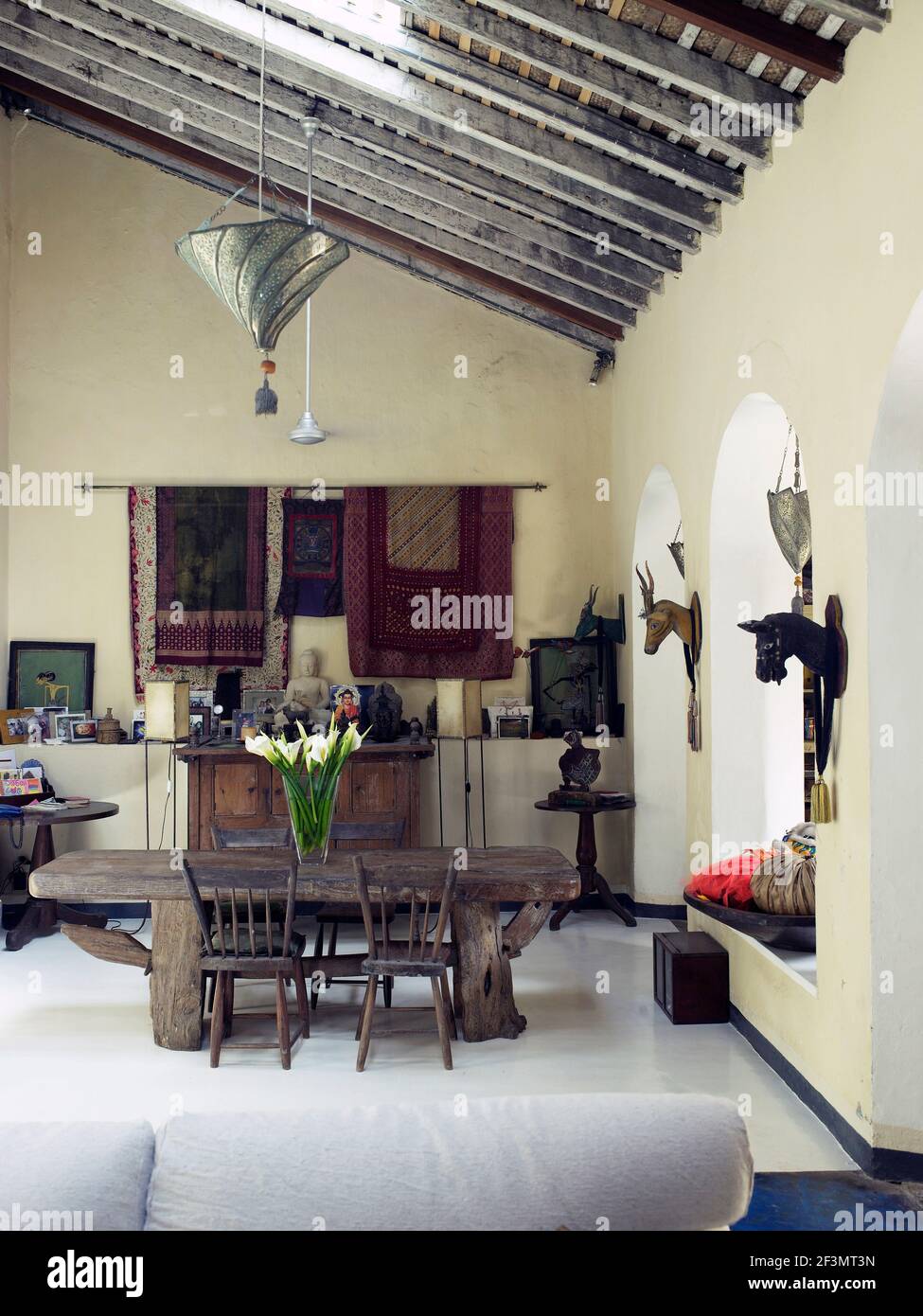 Table and chairs in country dining room with beamed ceiling, Sri Lanka