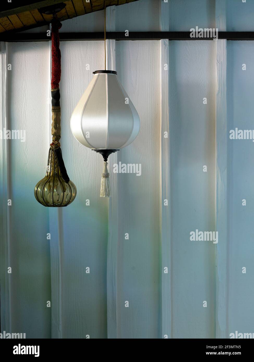 Pendant light seen against painted wood wall in USA home Stock Photo