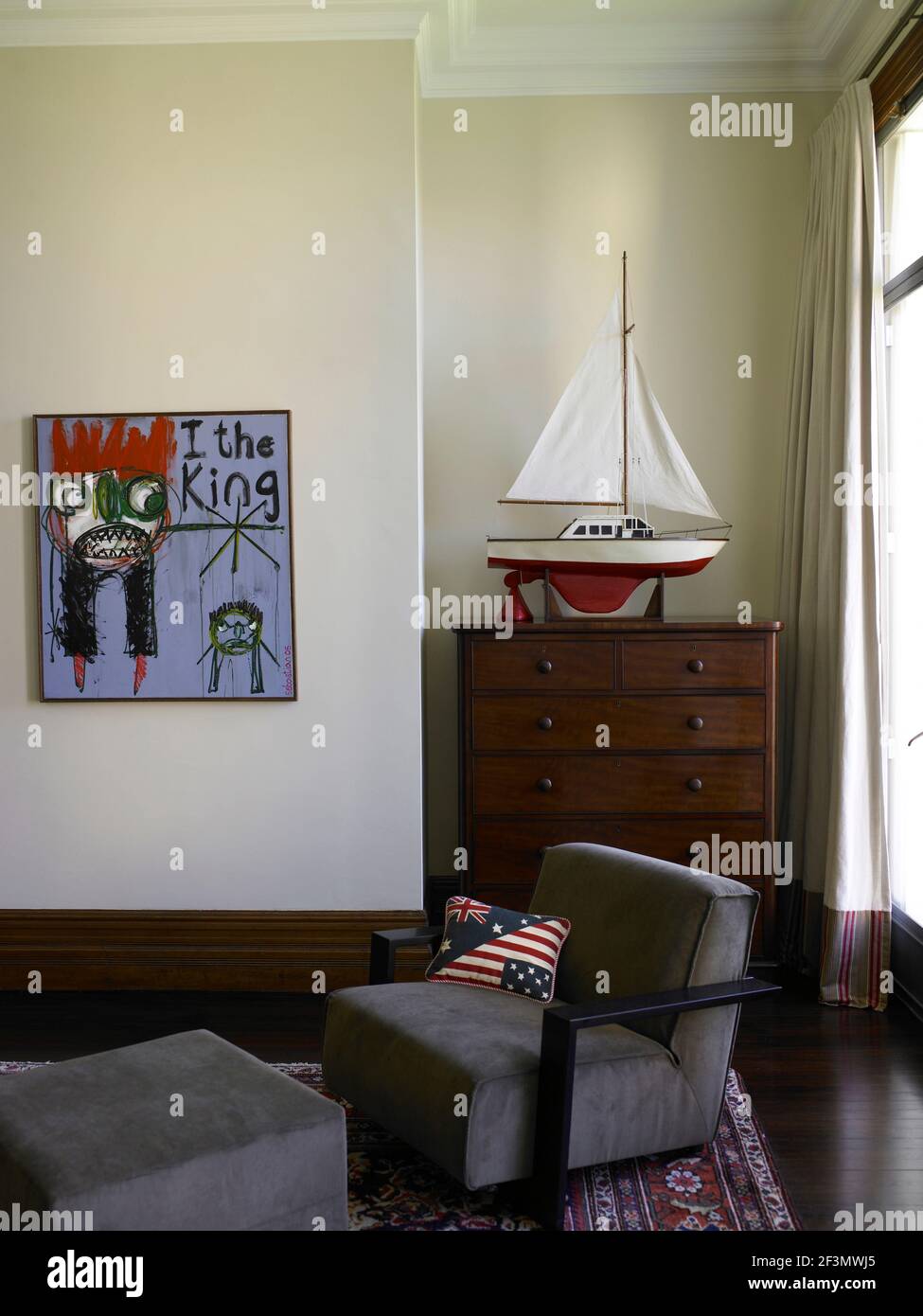 Armchair in front of chest of drawers in bedroom, Australia Stock Photo