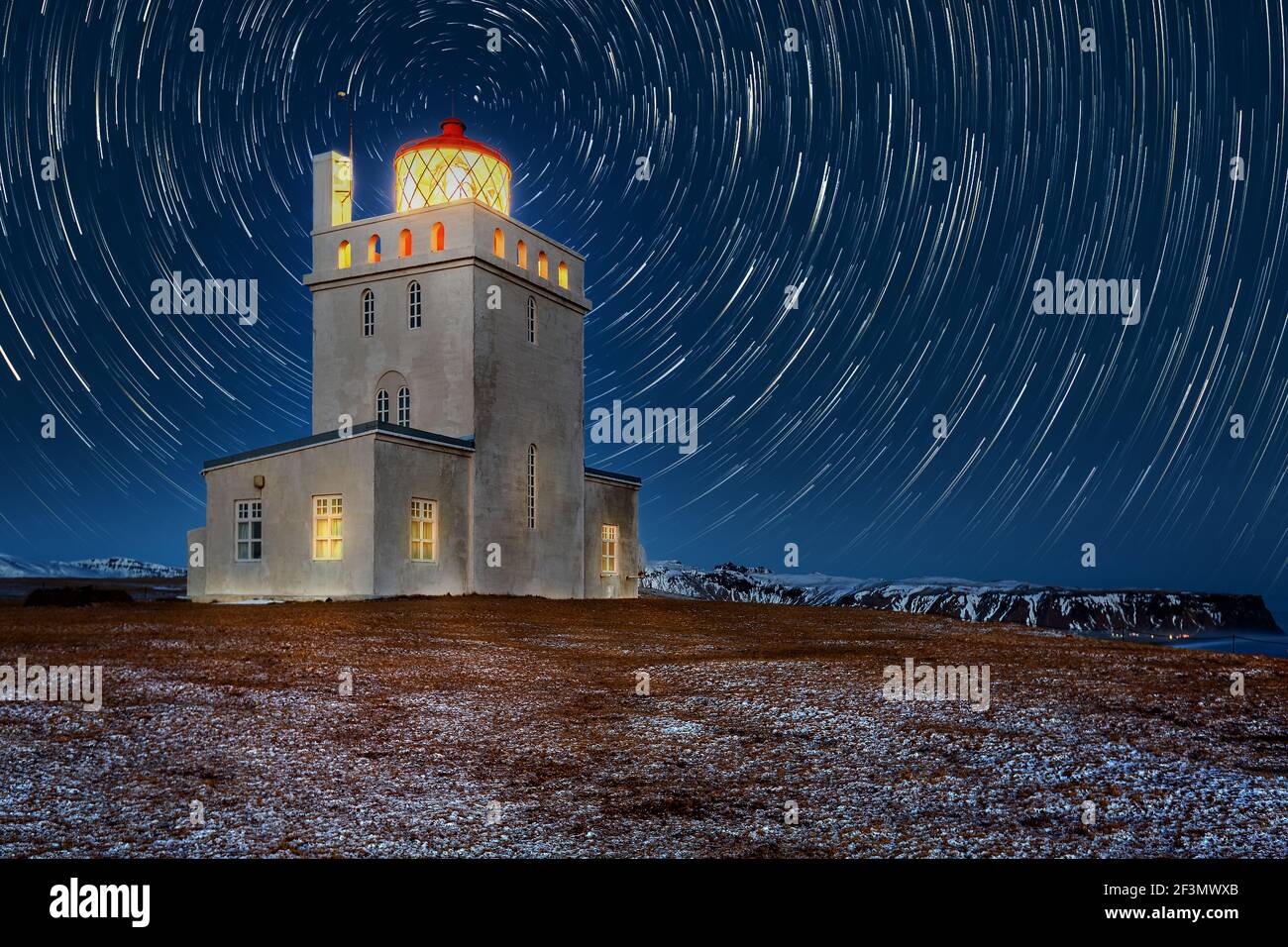 Dyrholaey lighthouse under star trails. The light station at Dyrholaey was established in 1910, near the village Vik, on the southern tip of Iceland. Stock Photo