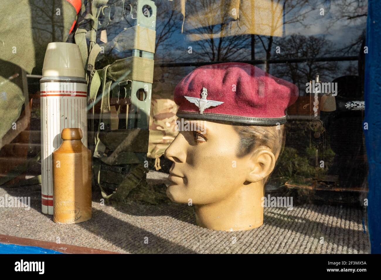 Glover & Riding military and civilian tailors shop in Aldershot, Hampshire, England, UK. Shop window display with mannequin in a para beret. Stock Photo
