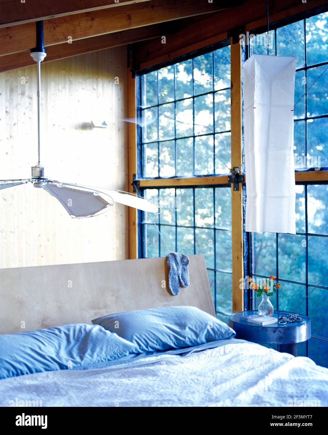 Ceiling fan above bed with blue pillows, USA Stock Photo Alamy