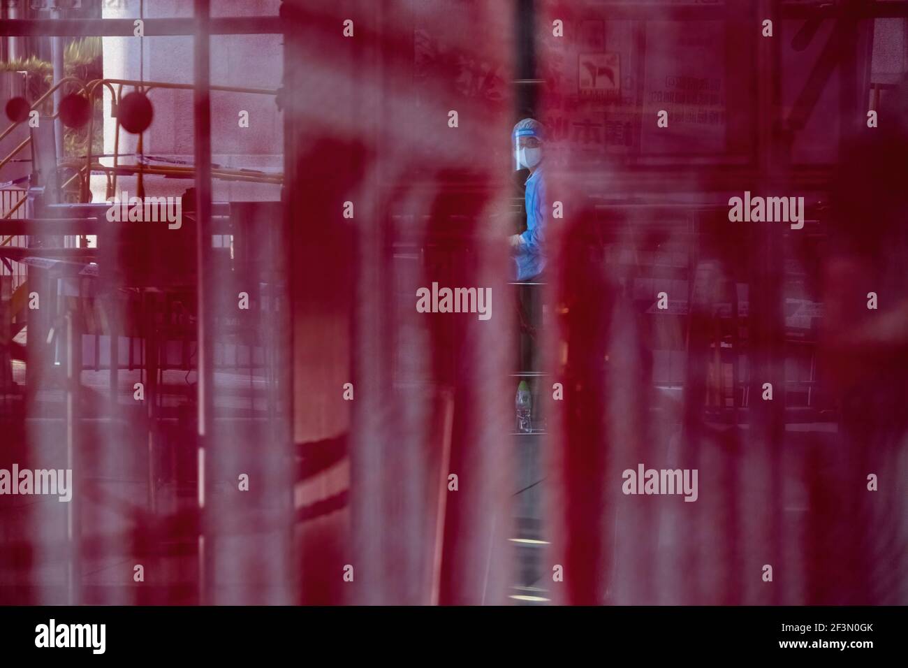 Hong Kong, Hong Kong. 17th Mar, 2021. A worker is seen through the