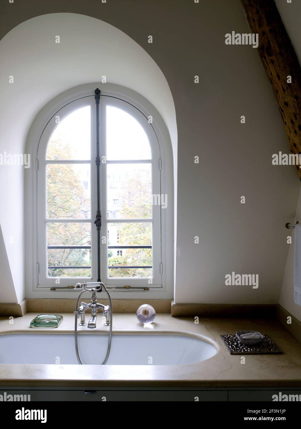 Bathtub beneath window in bathroom in French home Stock Photo Alamy