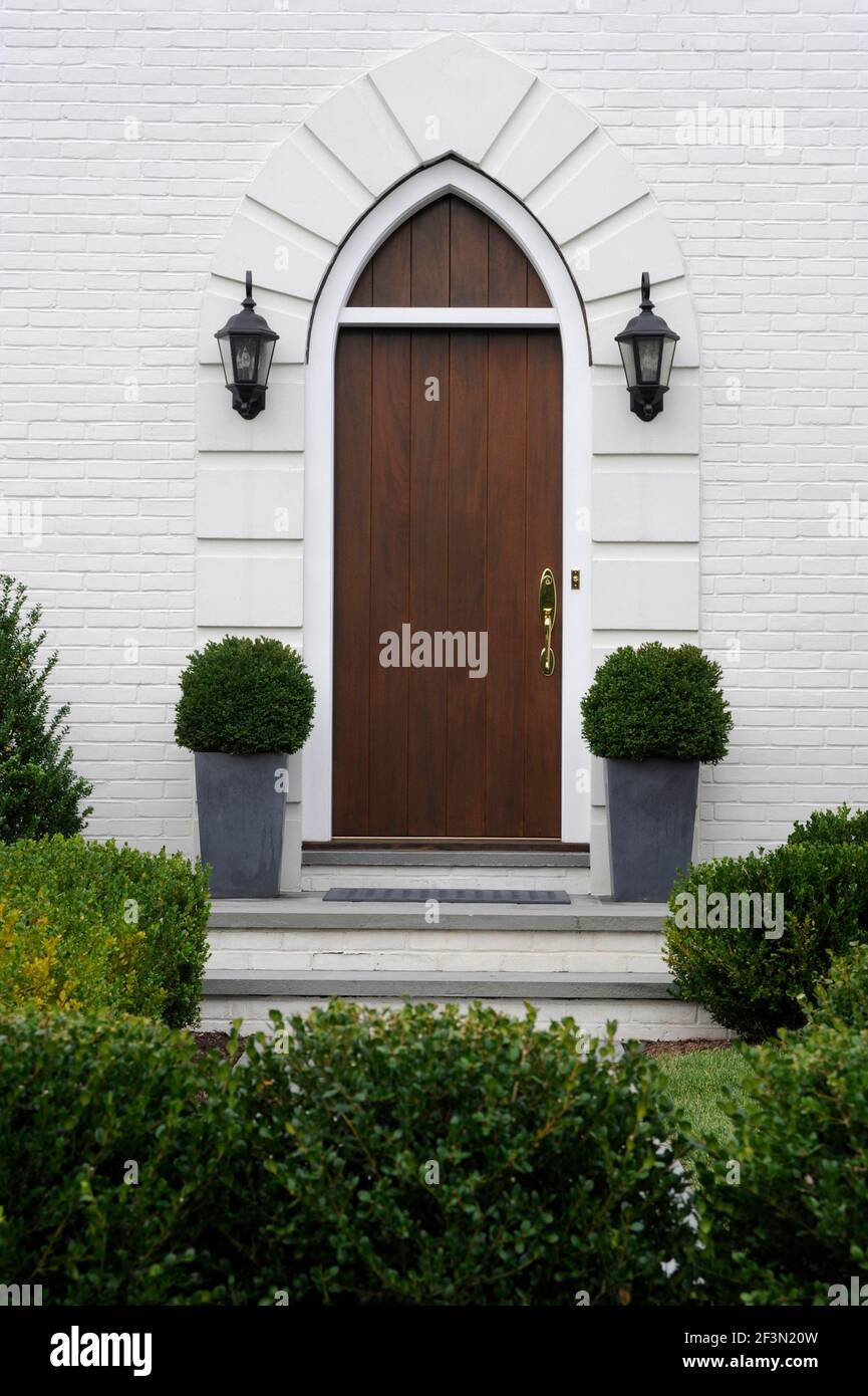 Wooden front door with container plants, contemporary transitional townhouse, Stamford, Fairfield County, Connecticut, USA Stock Photo