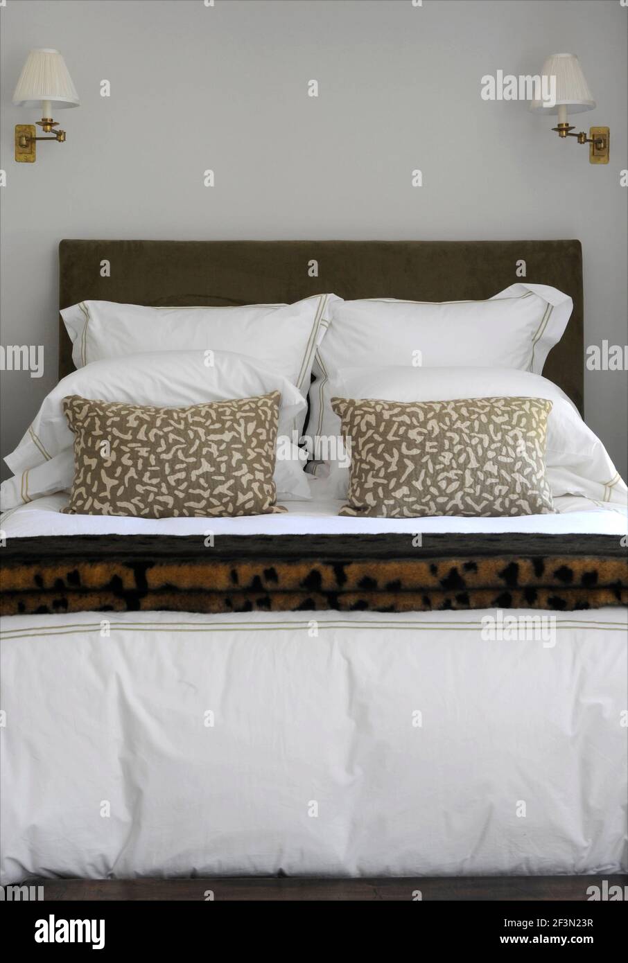 Double bed with patterned cushions and wall lighting in Shelley Morris Designed Colonial style residence in New Canaan, Connecticut, USA Stock Photo