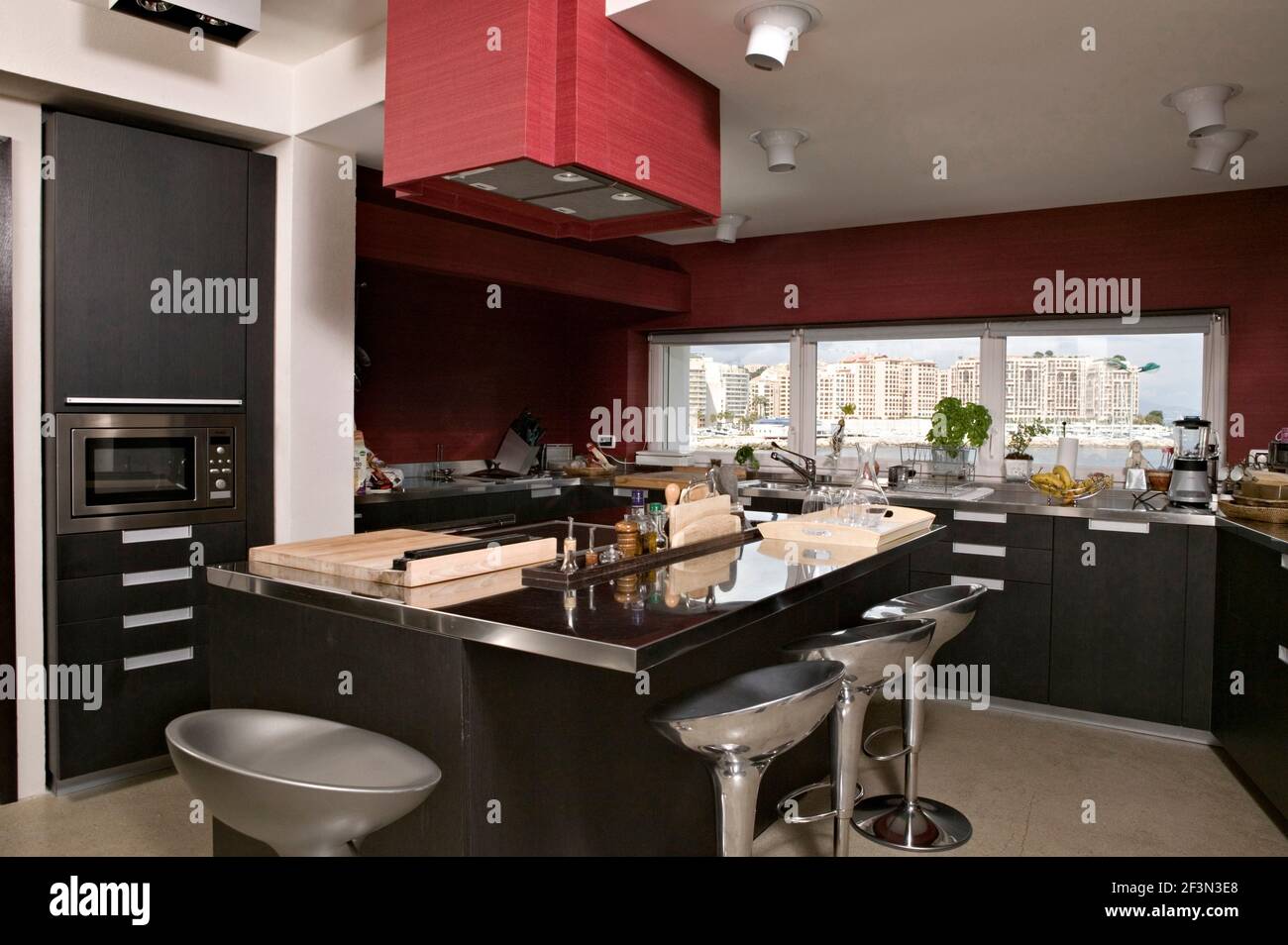 Bar stools at breakfast bar in red kitchen Stock Photo