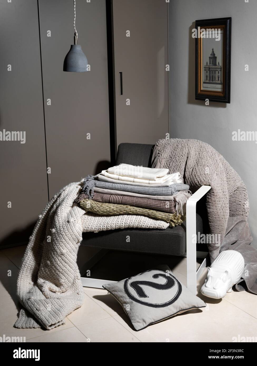 Folded throws on armchair, UK home Stock Photo Alamy