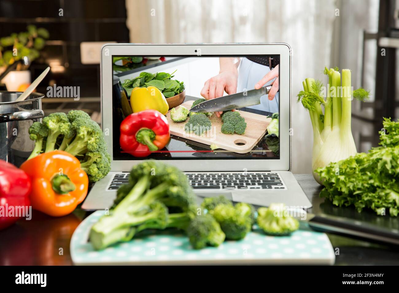 Beautiful happy woman streaming broadcast video blog about tasty and healthy food from home kitchen. Healthy lifestyle and social media. Man watching Stock Photo