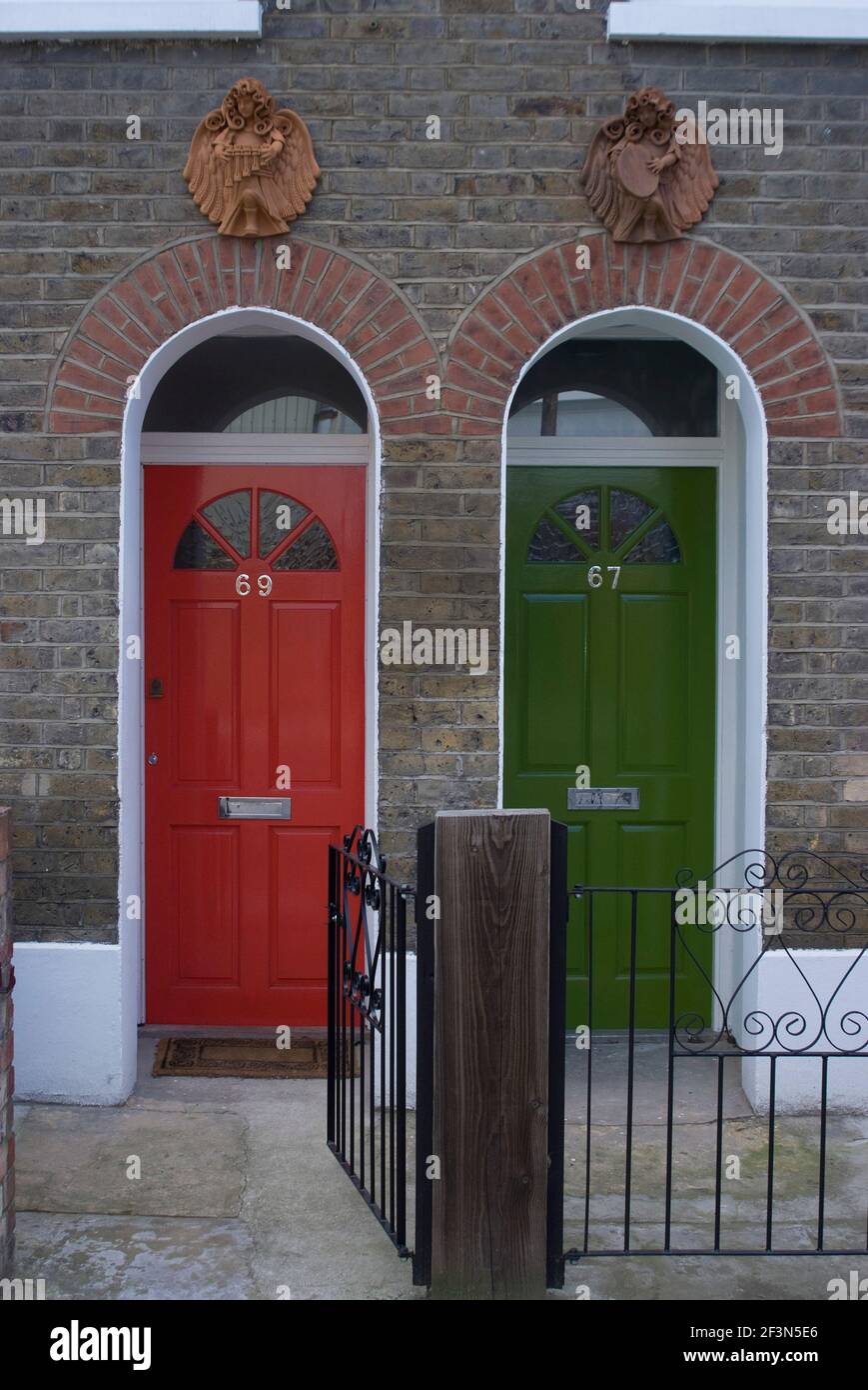 Red and green doors of two adjoining flats in a terrace house, Greenwich, SE10, Londo | NONE | Stock Photo