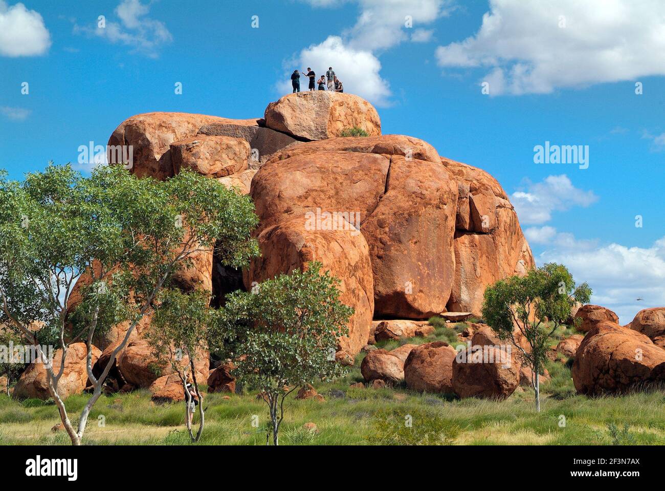Waramungu, Australia April 19, 2010: Unidentified tourists on top of natural landmark and Aborigines sacred site Devils Marbles in Northern Territory Stock Photo