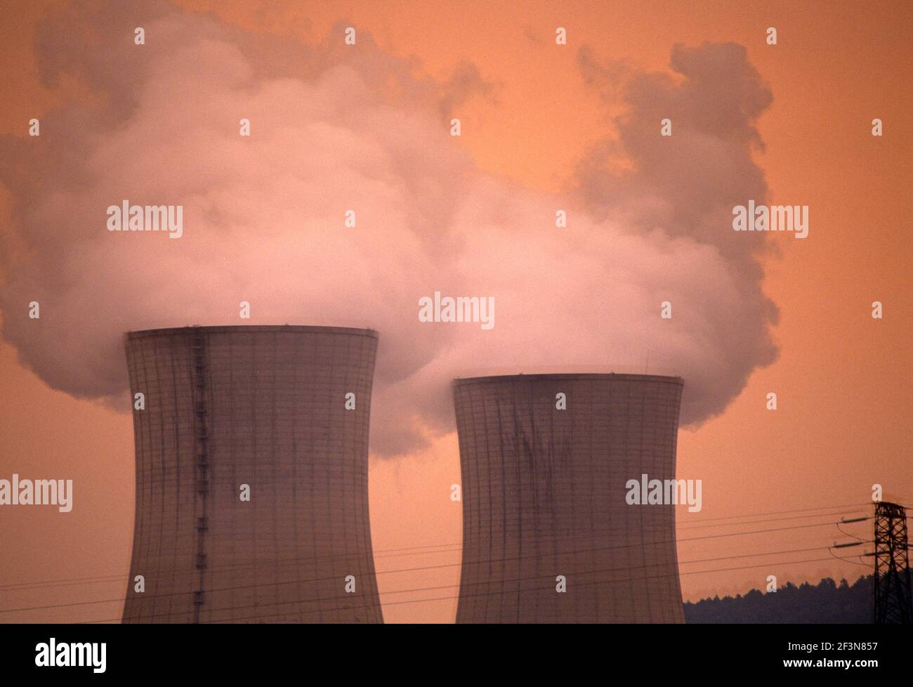 Tricastin nuclear power station. Near Montelimar. Steam from large chimneys. Orange sky. Drome Provencal. Stock Photo