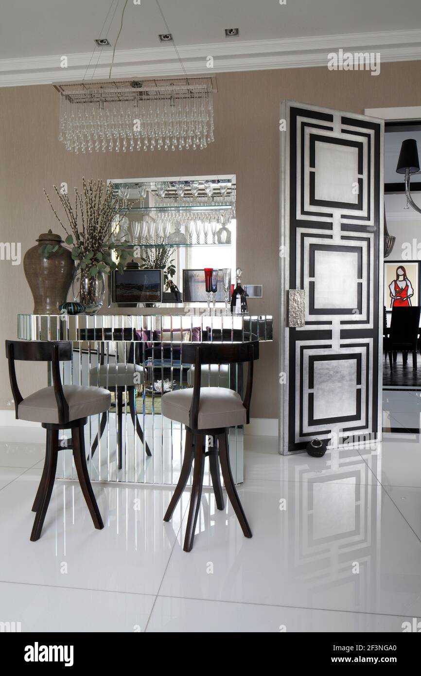 Mirrored cocktail bar and barstools on highly polished tile floor in drawing room |  | Designer: Jordana Yechiel Stock Photo