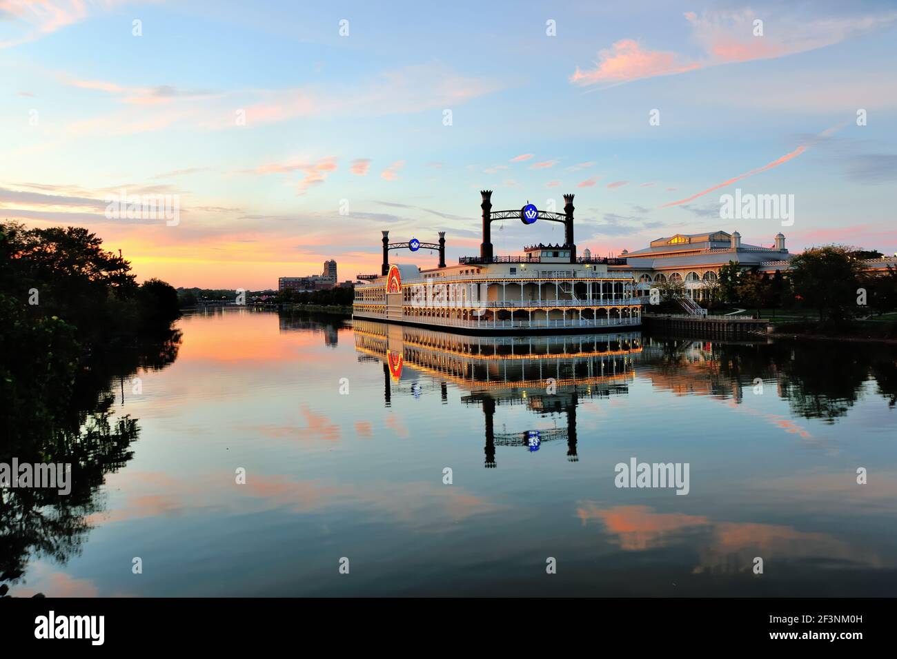 Elgin, Illinois, USA. The Grand Victoria Riverboat Casino reflecting a muted sunset while casting its own reflection in the Fox River. Stock Photo