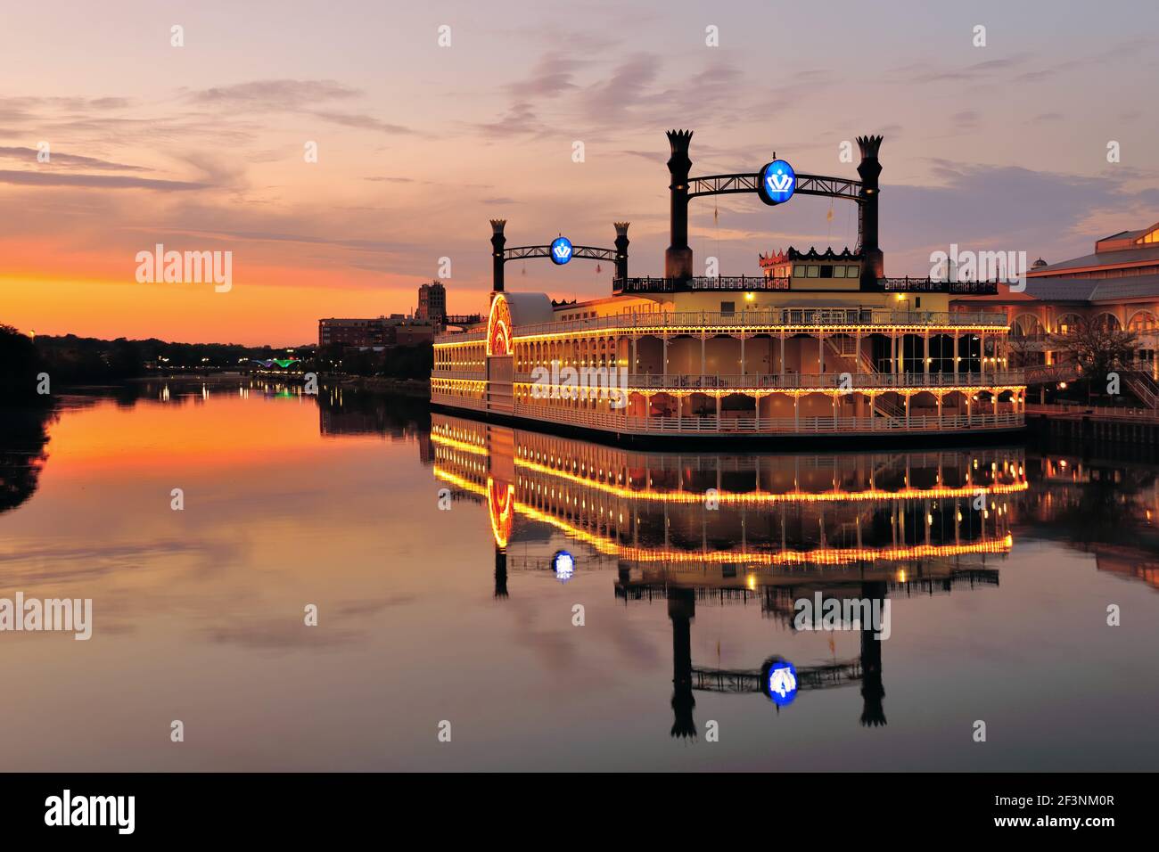 Elgin, Illinois, USA. The Grand Victoria Riverboat Casino reflecting a muted sunset while casting its own reflection in the Fox River. Stock Photo