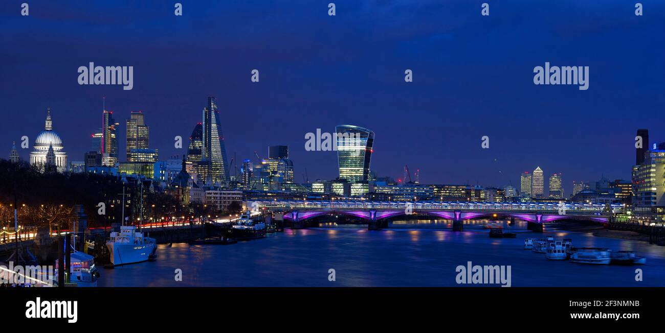 Dusk panorama. The city of London skyline, with St Paul's cathedral lit up, bridges and modern buildings. The River Thames. Stock Photo