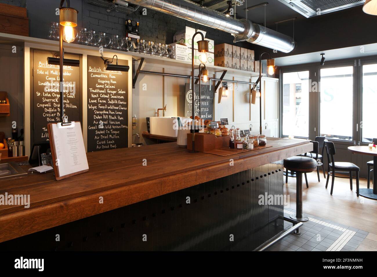 Cafe counter with oak top and light poles, with blackboards behind |  | Designer: Central Design Studio Stock Photo