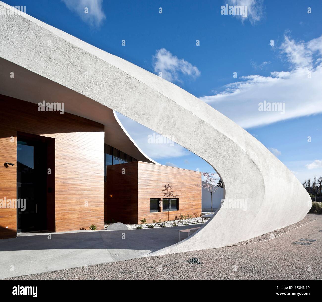 A dramatic white curved outer structure around a building which offers ...