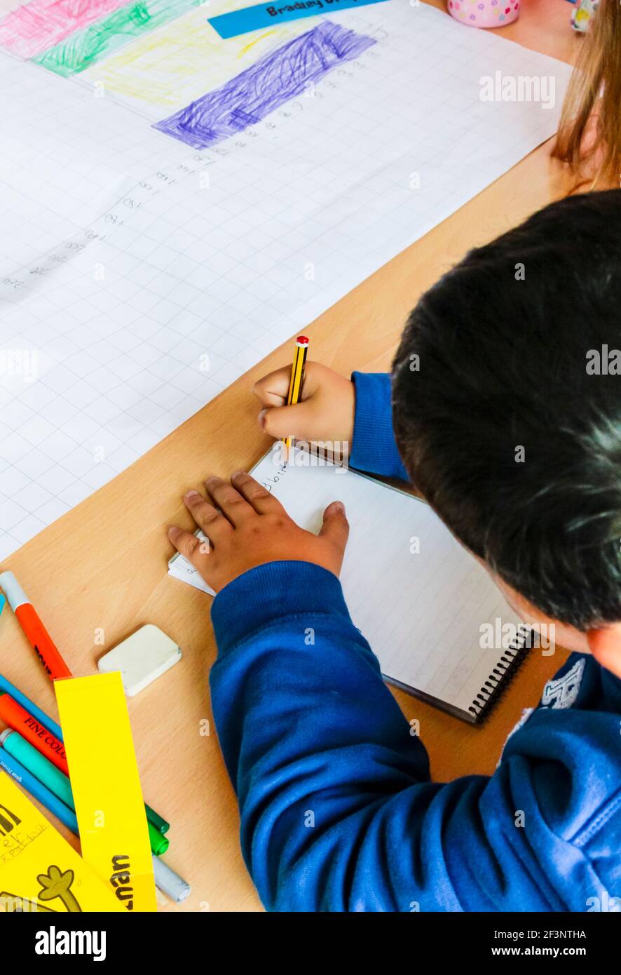 Child Writing Image Primary school child writing on a desk during a lesson Stock Photo - Alamy