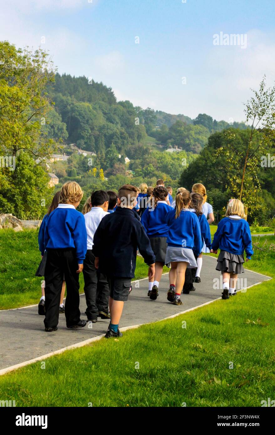Group of primary school children in school uniform making their way back to the classroom after a break in the lessons. Stock Photo