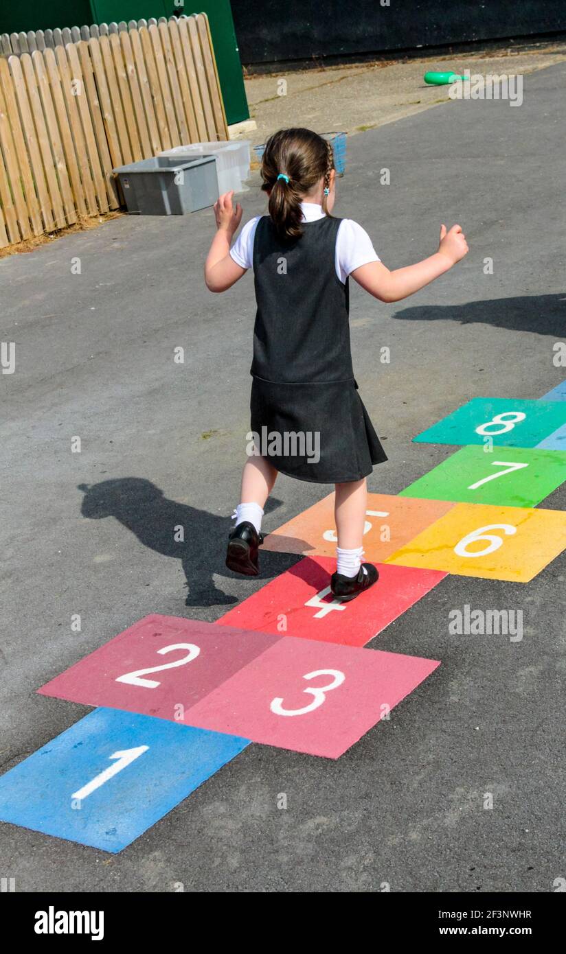 Primary school child playing hopscotch in a school playground during ...