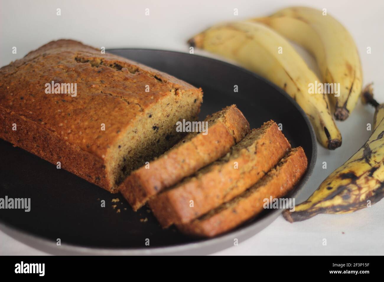 Slices of home baked whole wheat ripe plantain cake. It is also called ripe plantain bread. Shot on a white background Stock Photo