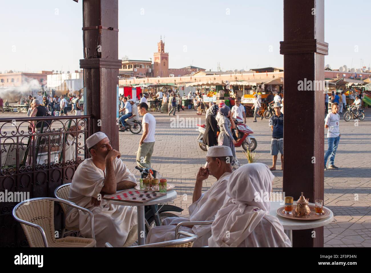 Two men playing checkers game in a cafe in front of Jamaa El Fna (also Jemaa el-Fnaa) market square in Marrakesh, Morocco Stock Photo