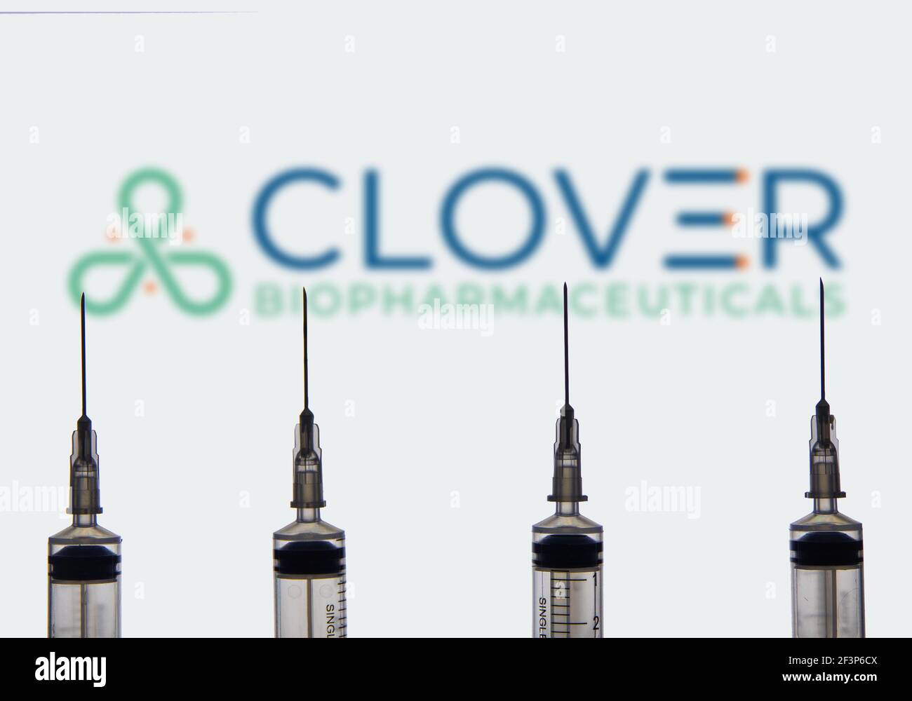 Kathmandu, Nepal - March 17 2021: Four syringe or injection needles against Clover Biopharmaceuticals logo in the background. Vaccine Concept. Stock Photo