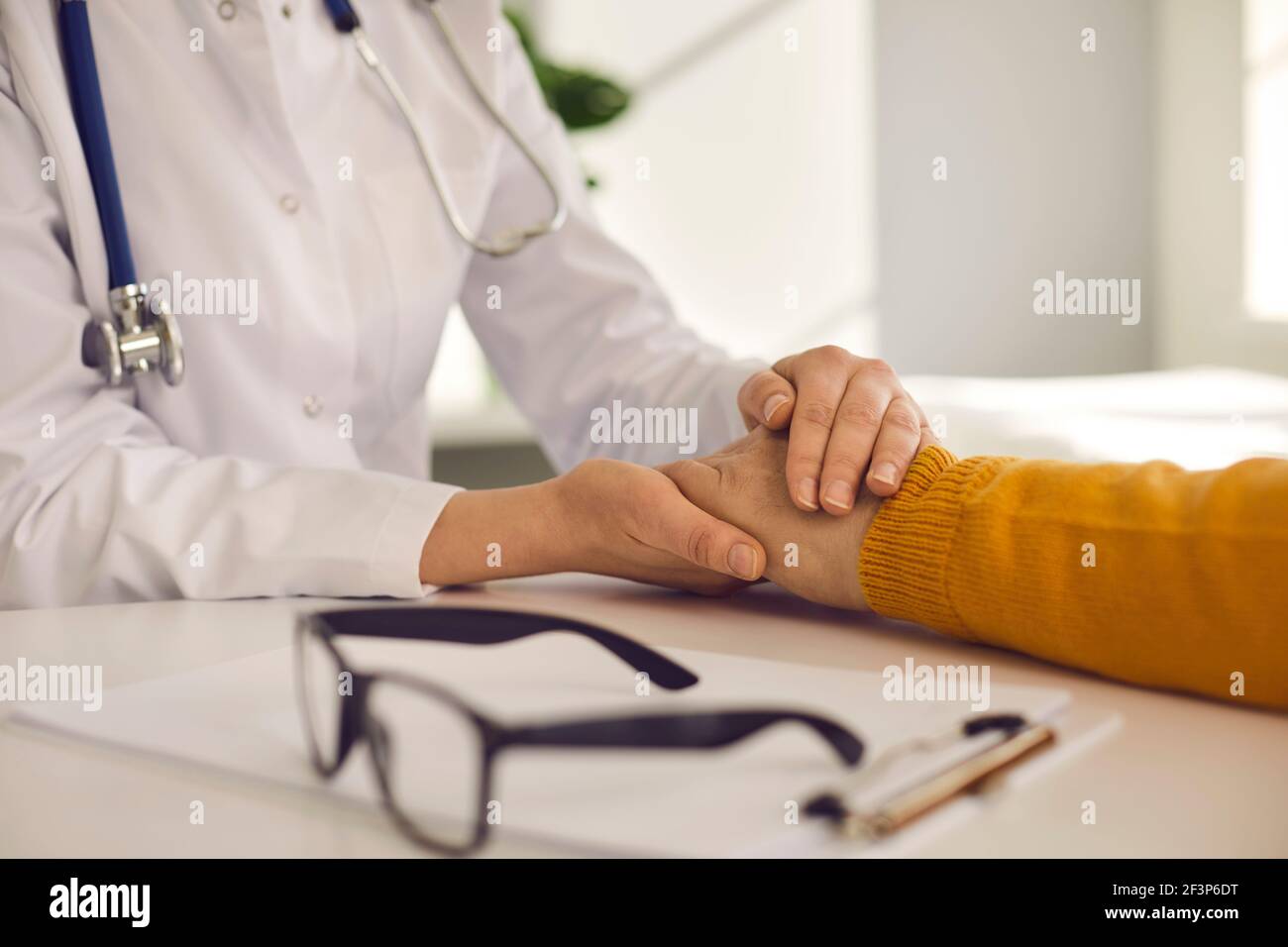 Closeup female doctor hold male patient hand give medical help support reassure Stock Photo