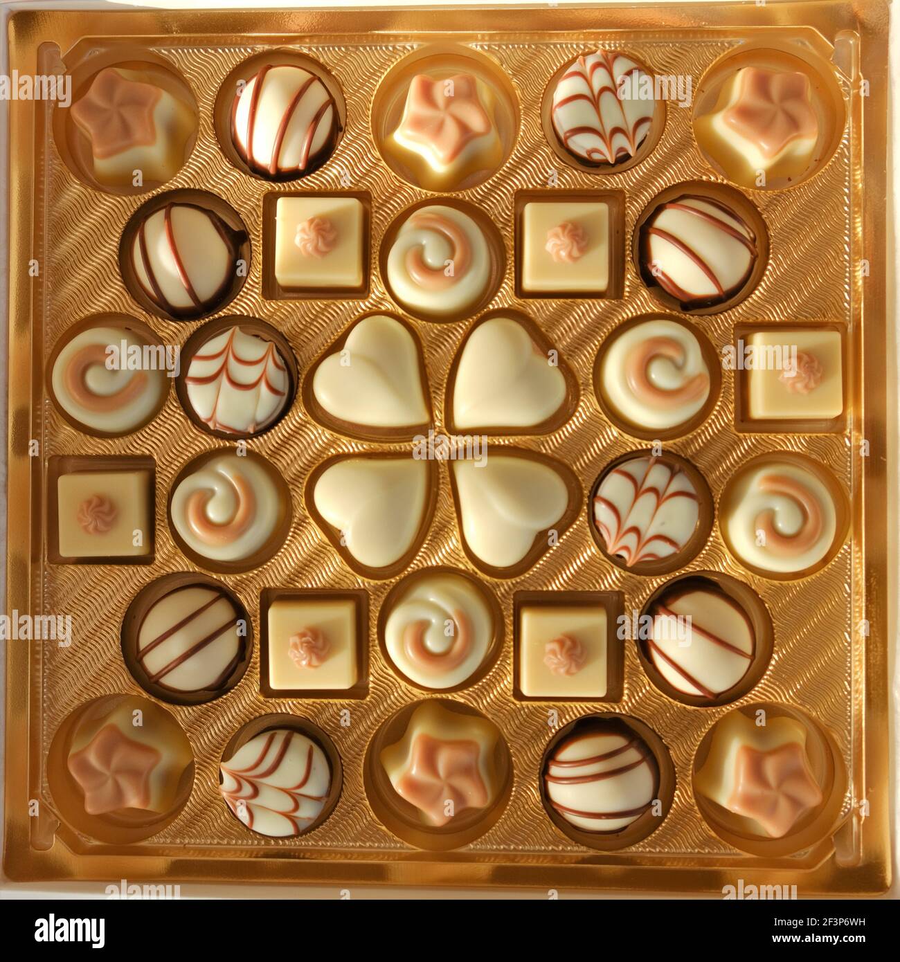 Chocolate candy .White chocolate. Assorted chocolate truffles in a gold